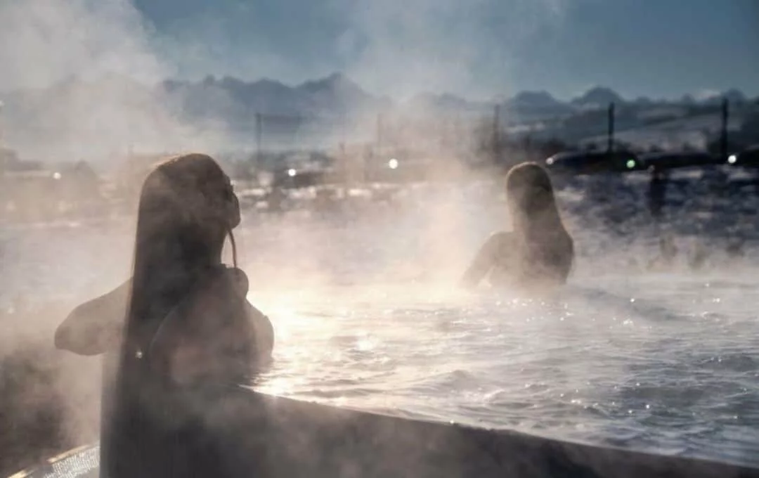 Outdoor thermal pool with steam rising in winter at Chochołów Baths